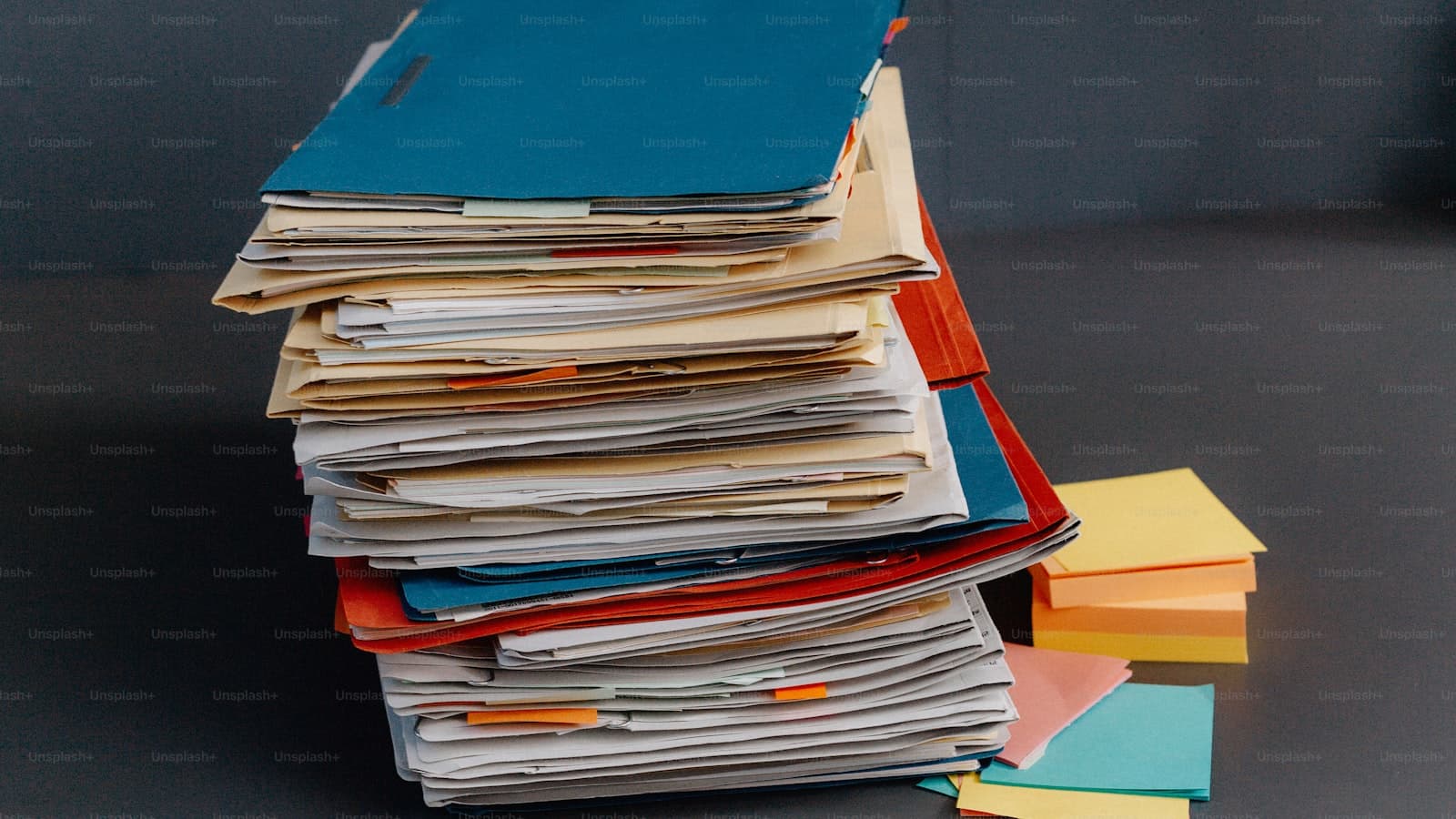 A stack of folders and papers on a desk