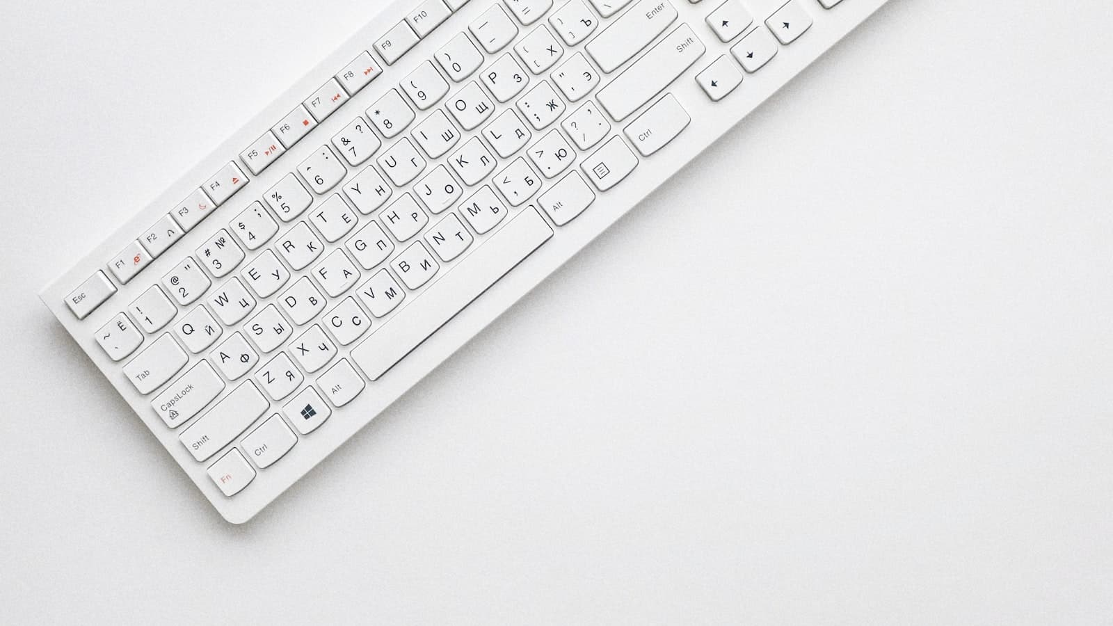 A compact white keyboard on a clean desk