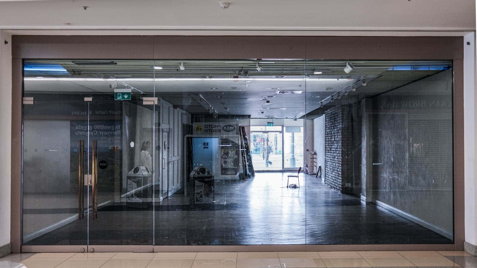 An empty storefront with reflective glass doors at dusk